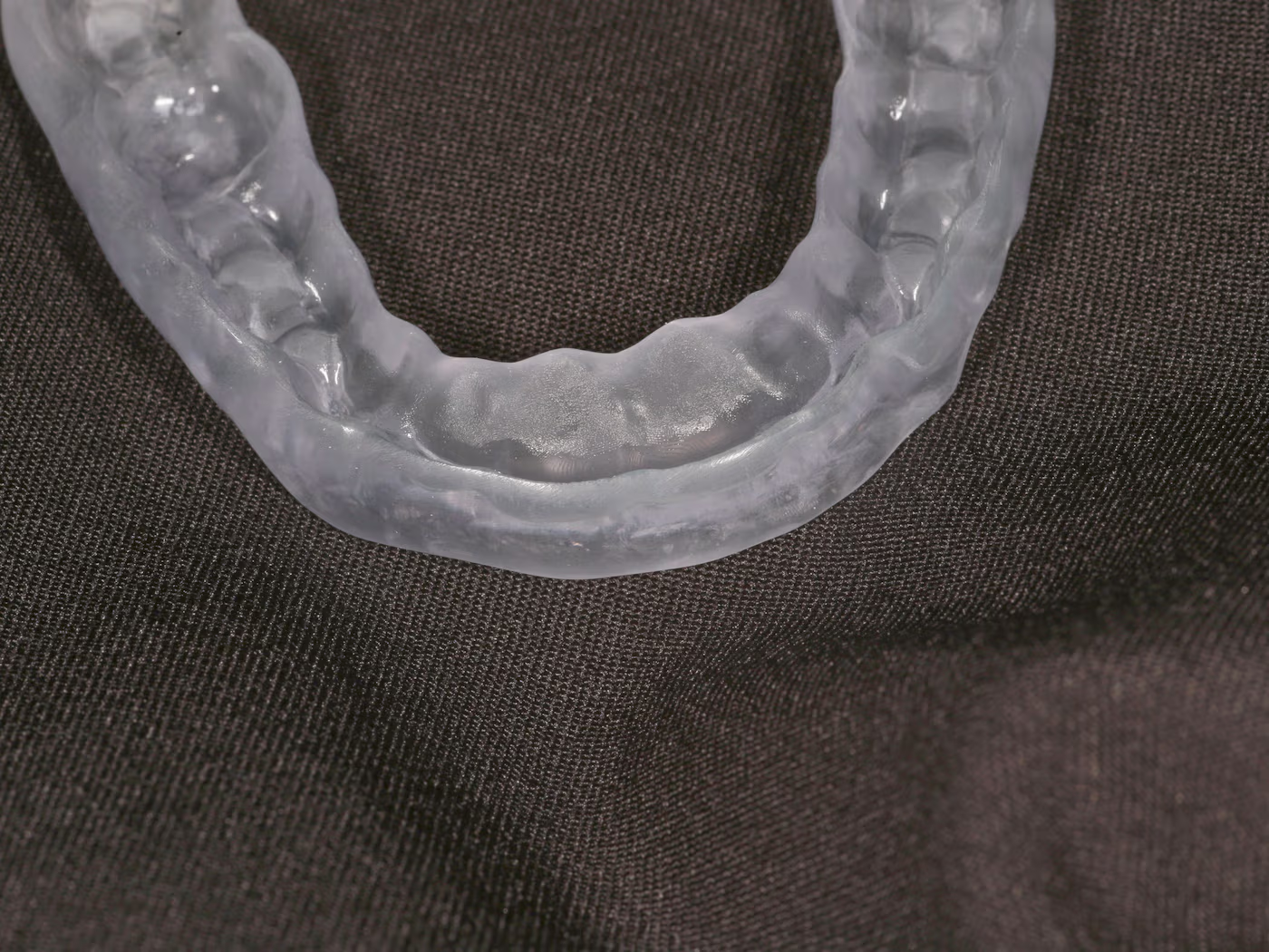 A clear printed occlusal splint, the kind of file that arrives as a scan and leaves as a design